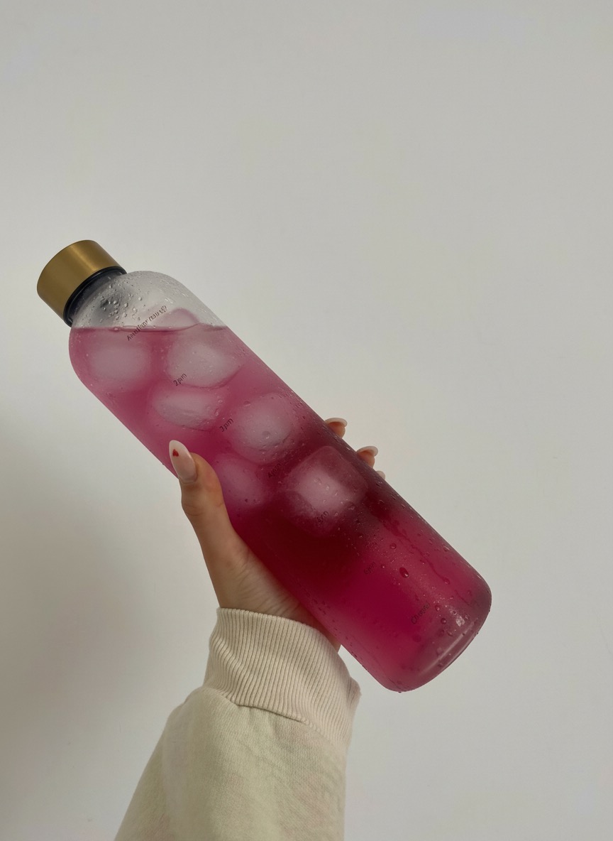 Slim Hunger Control drink held up against a soft white wall